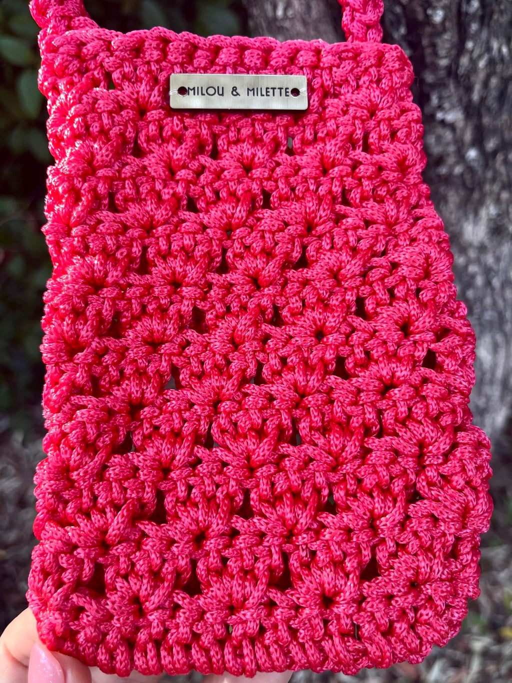 Pochette de téléphone rouge- Zoom sur la matière et l'étiquette en laiton
