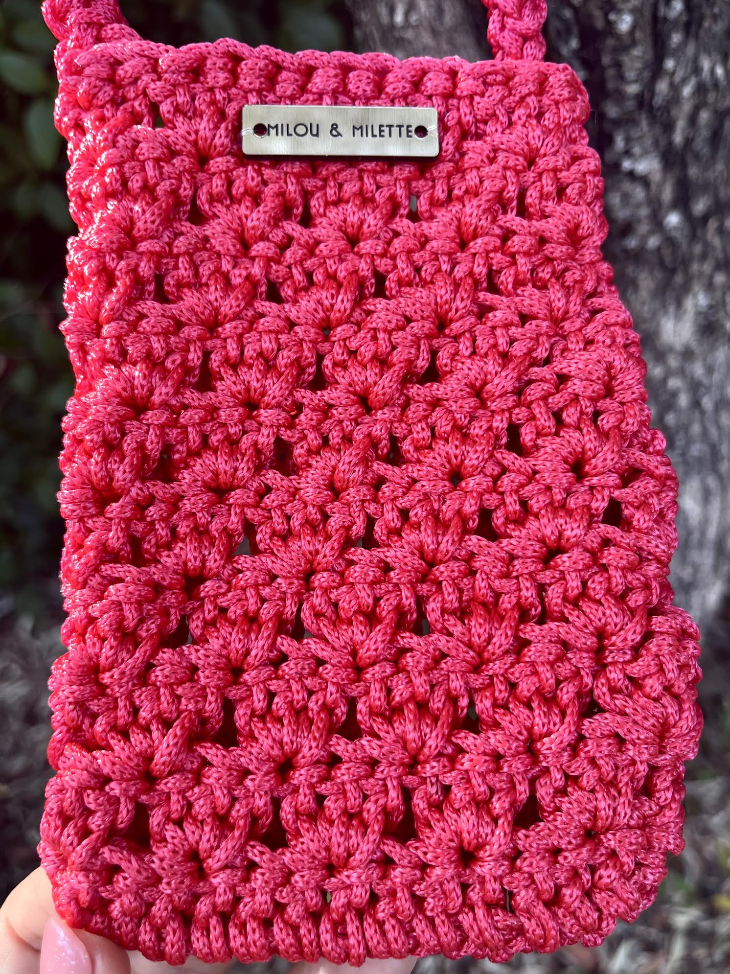 Pochette de téléphone rouge- Zoom sur la matière et l'étiquette en laiton