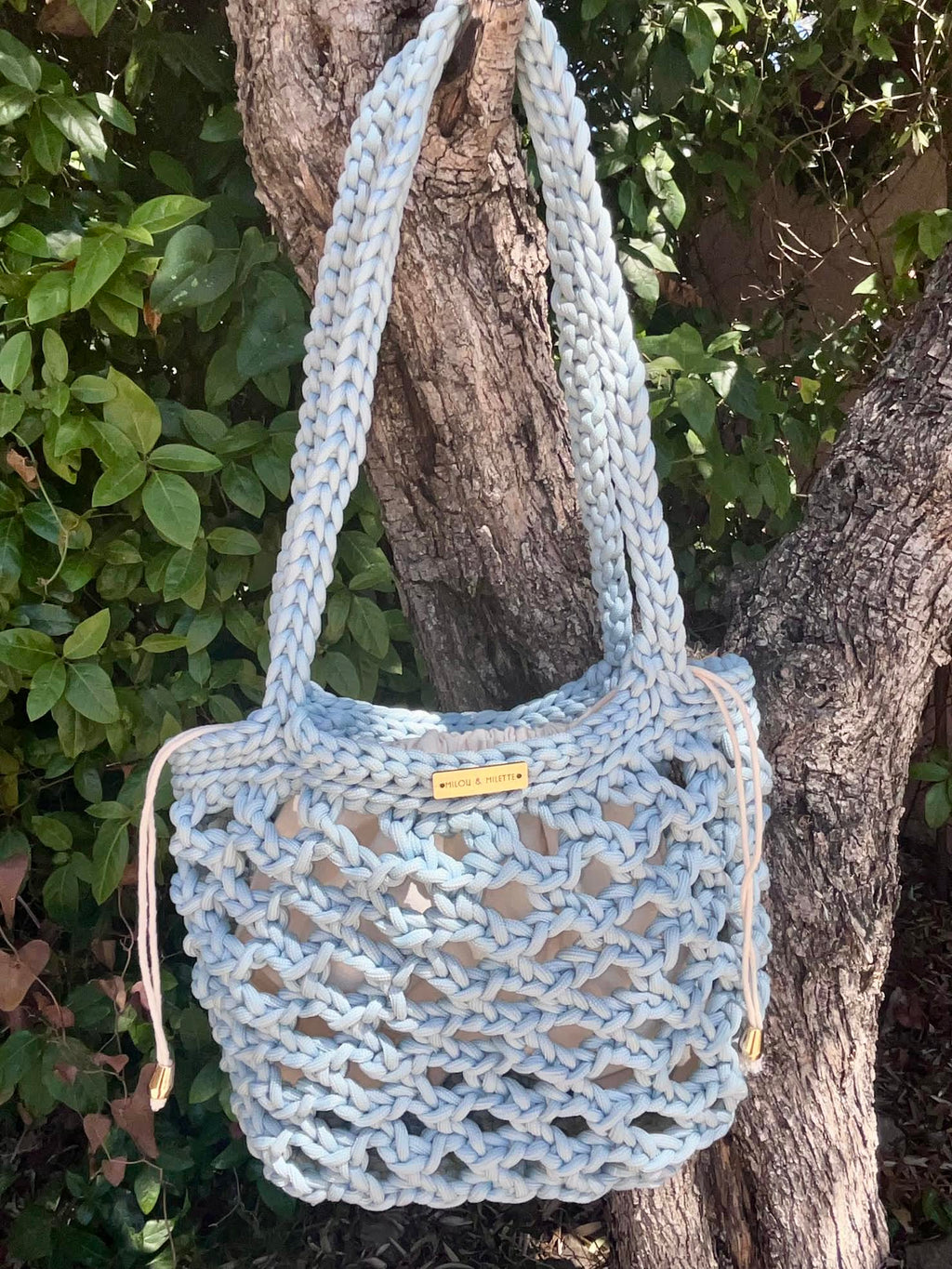 Sac cabas bleu azur suspendu mettant en valeur ses longues anses