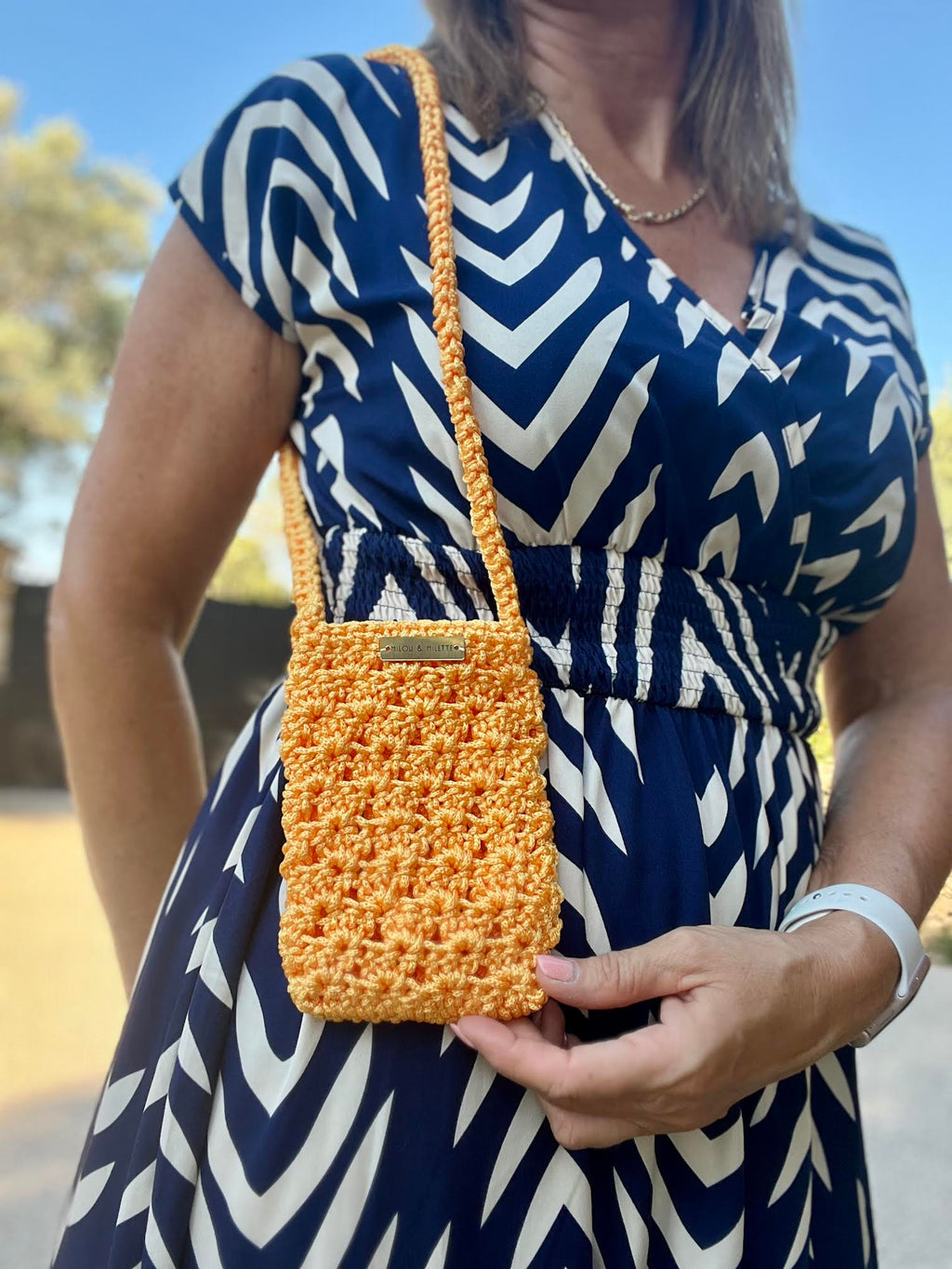 pochette téléphone au crochet orange soleil faite main et portée.Bandoulière pratique; pièce unique Milou & Milette. Zoom matière