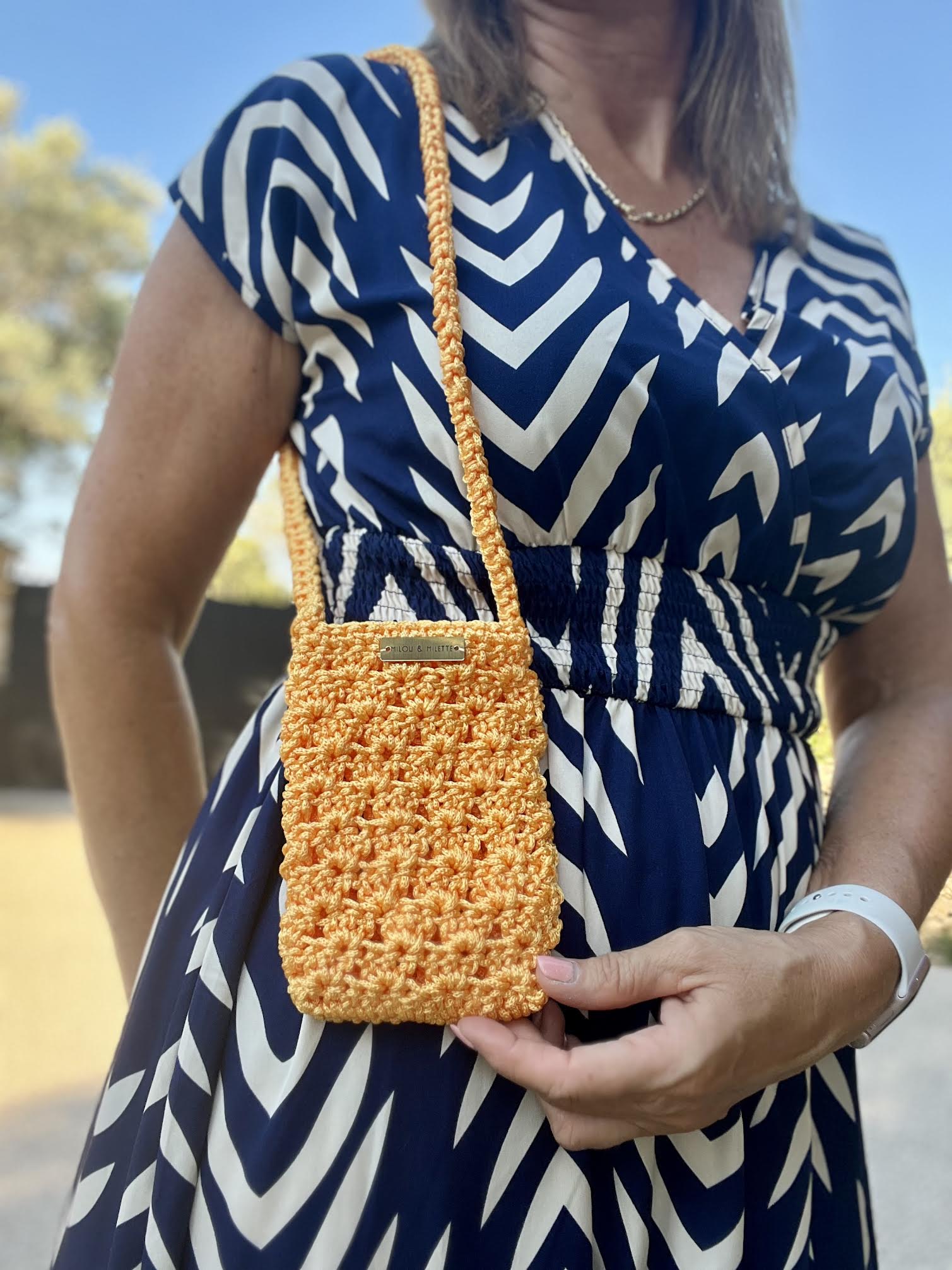 pochette téléphone au crochet orange soleil faite main et portée.Bandoulière pratique; pièce unique Milou & Milette. Zoom matière