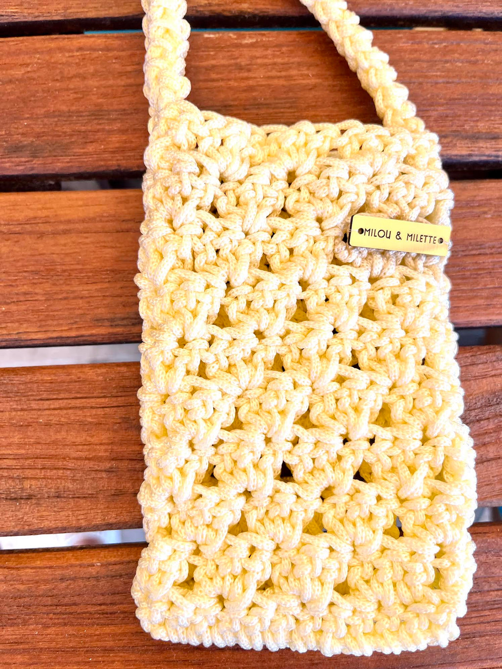 Pochette téléphone vanille détails de la maille et plaque signature