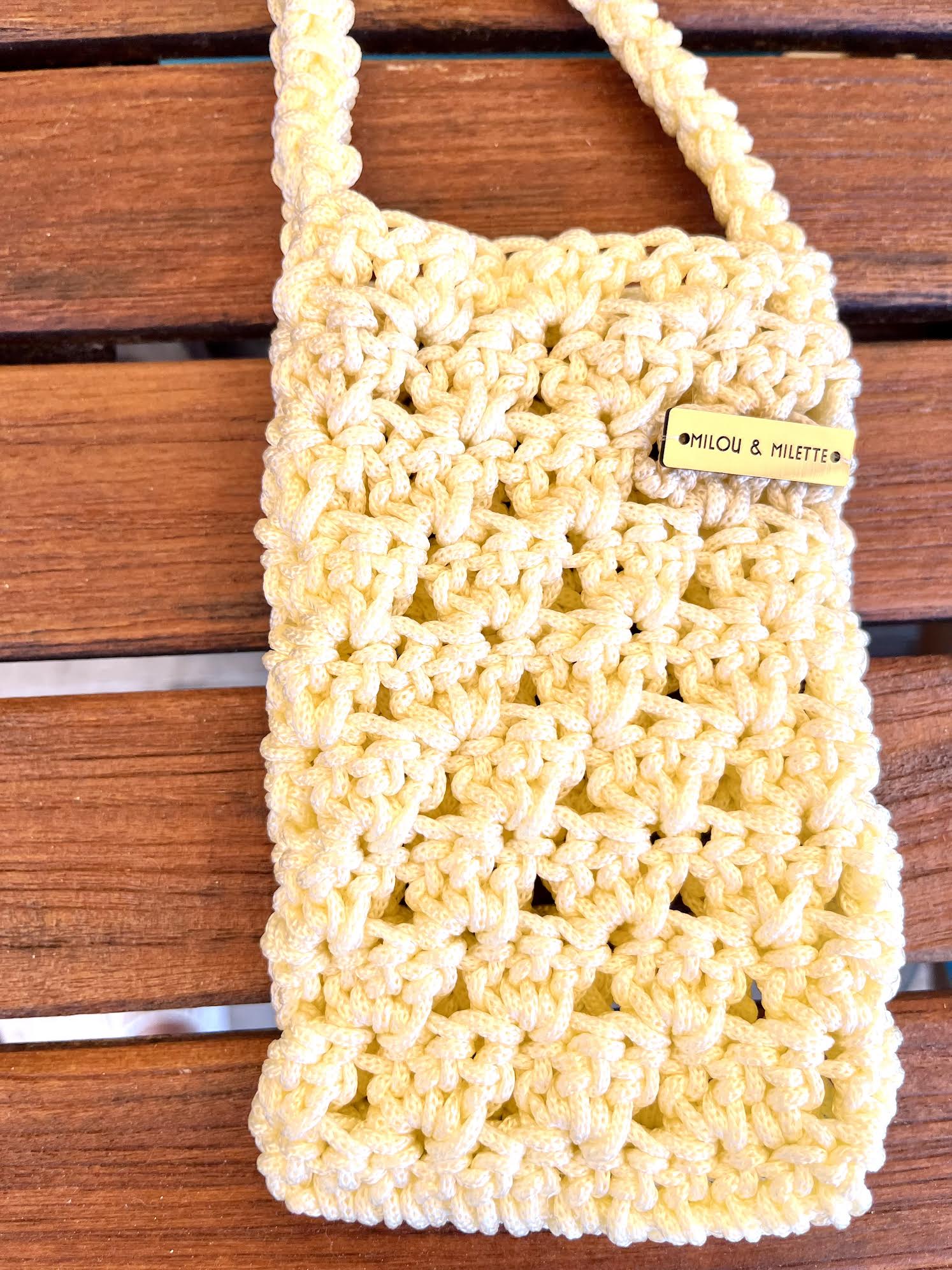 Pochette téléphone vanille détails de la maille et plaque signature